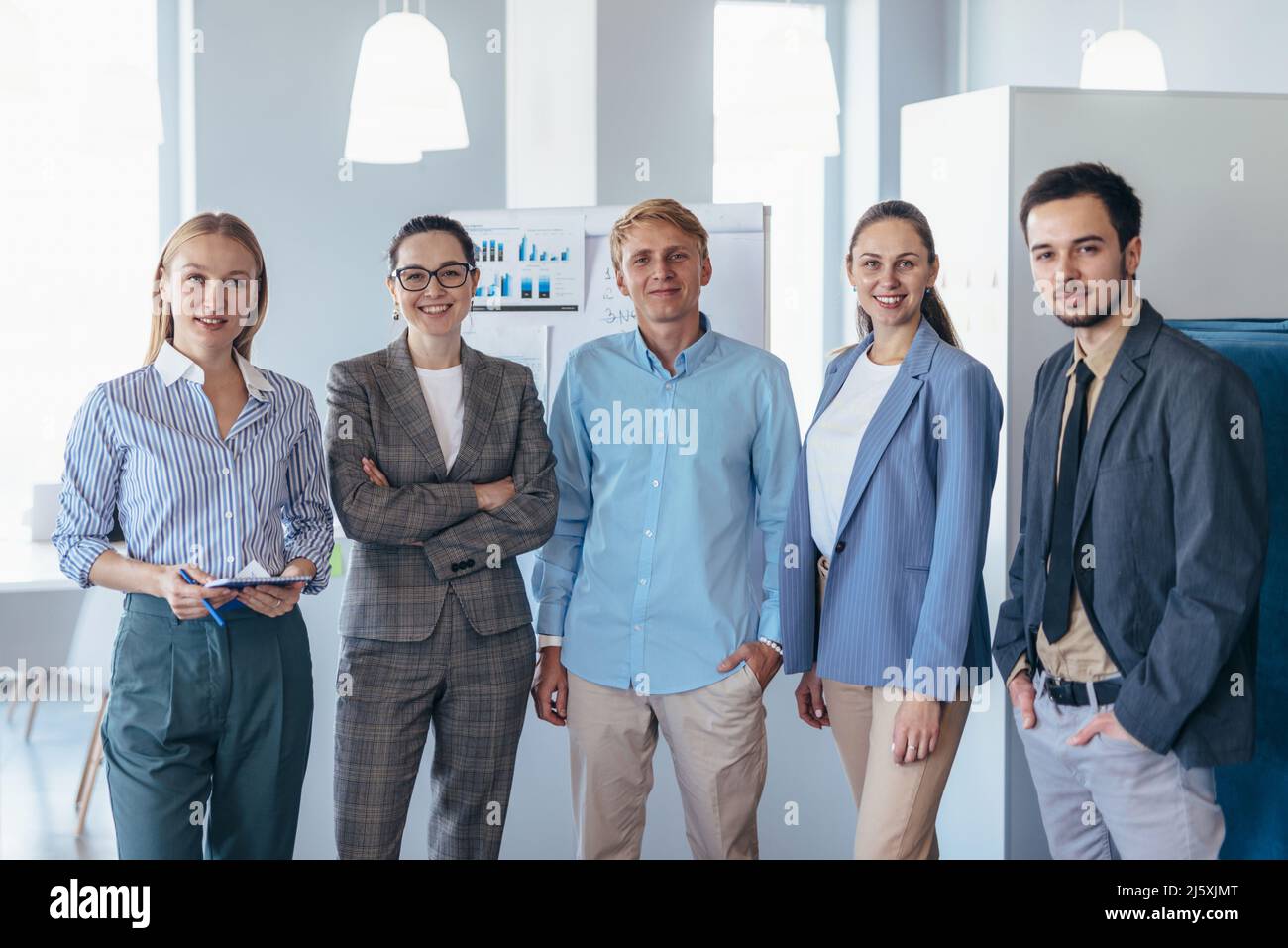 Portrait of business team standing together in office Stock Photo - Alamy