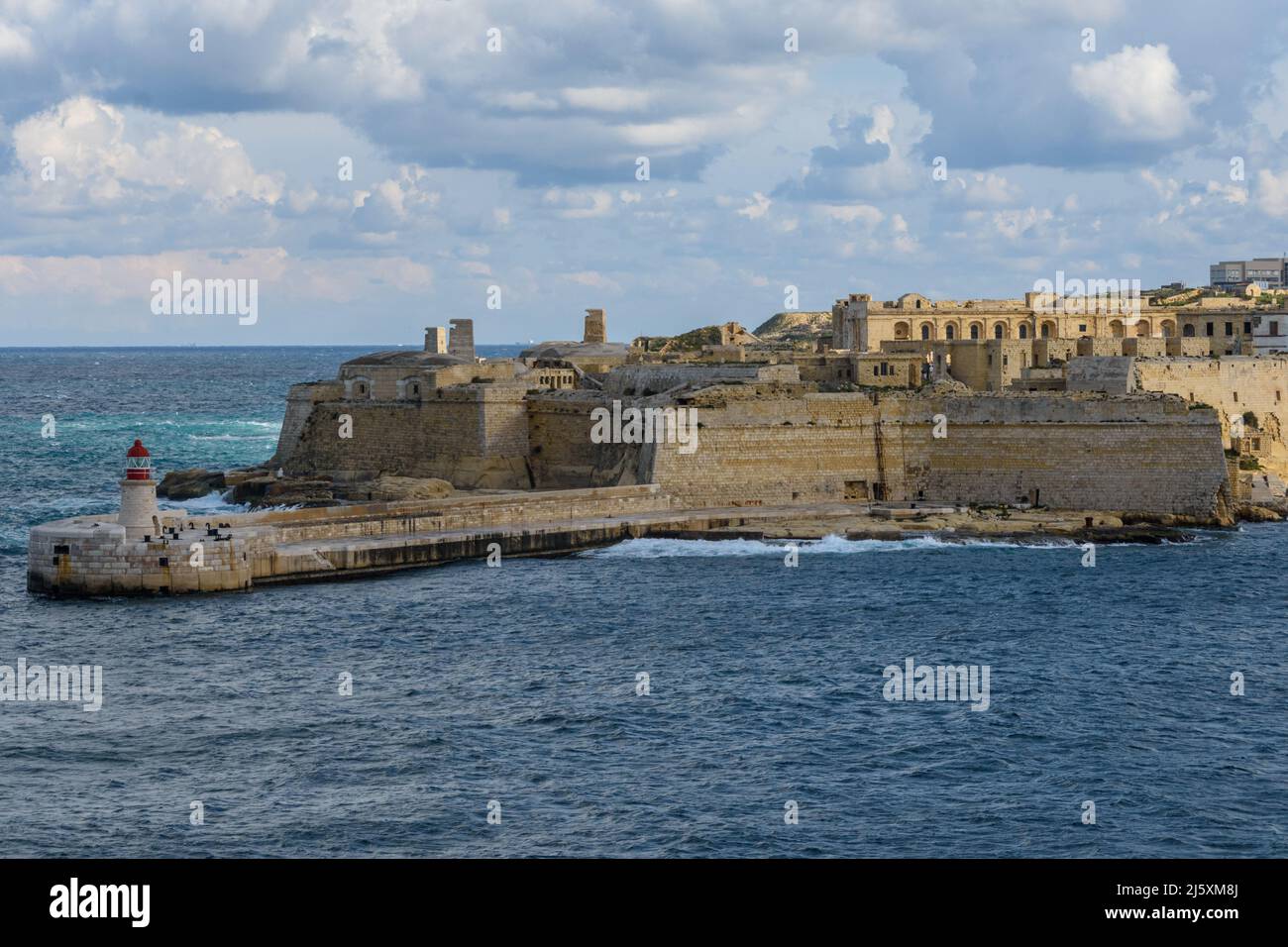 Kalkara, Malta - January 12th 2019: The lighthouse on the Ricasoli Breakwater with the 17th century Fort Ricasoli. Stock Photo