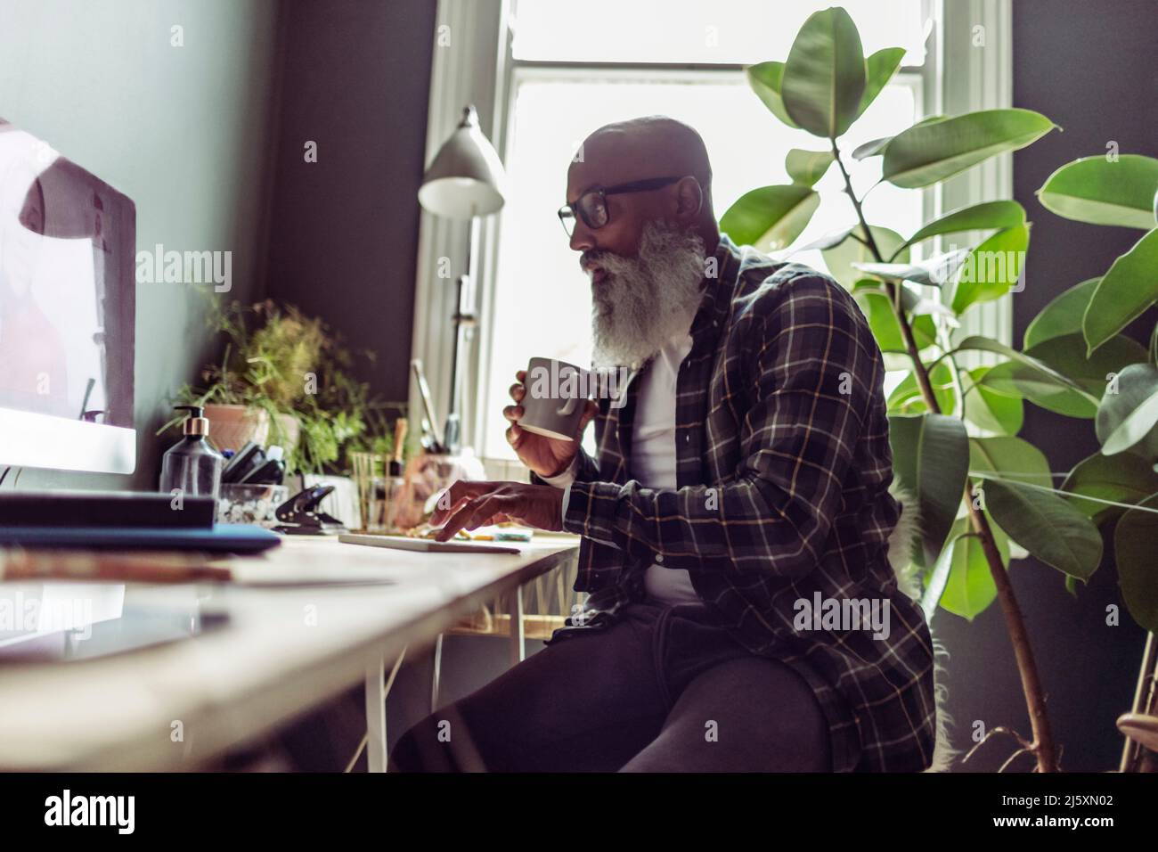 Senior man working at computer in home office Stock Photo