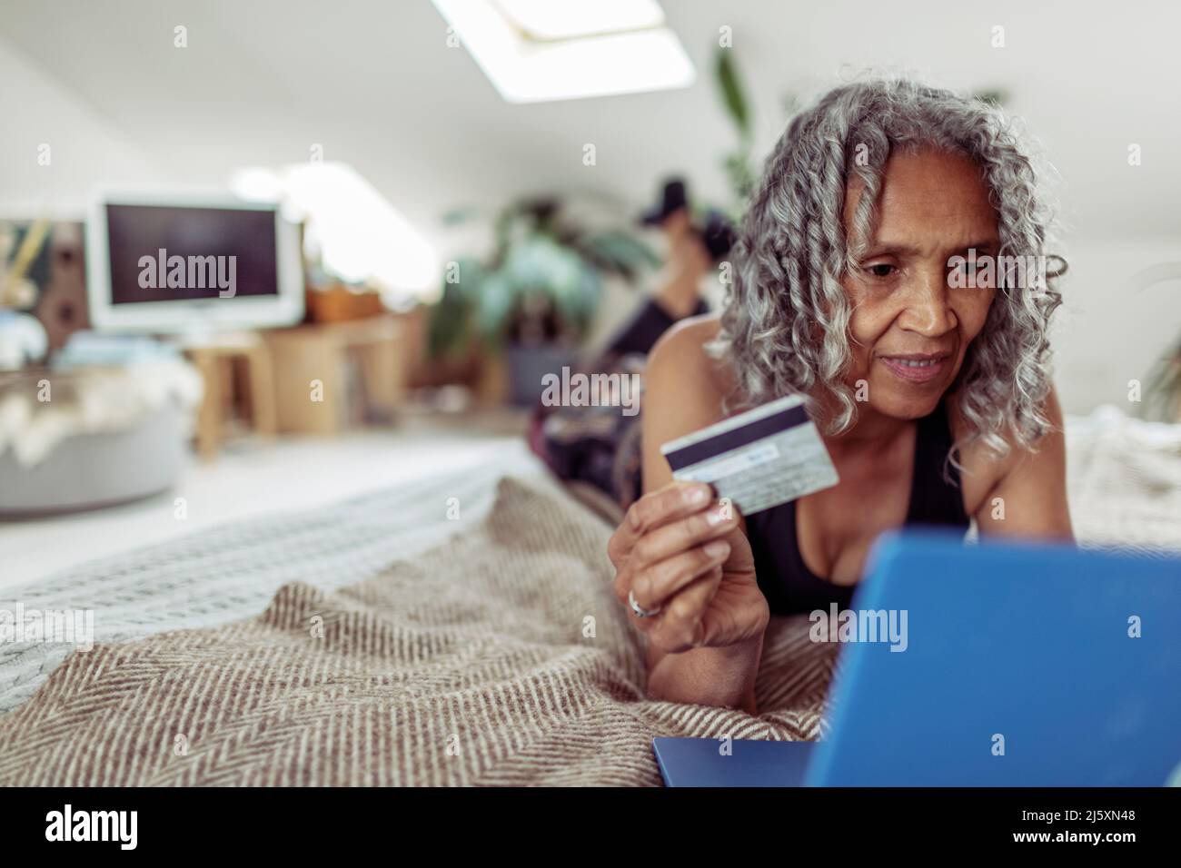 Senior woman with credit card online shopping at laptop Stock Photo