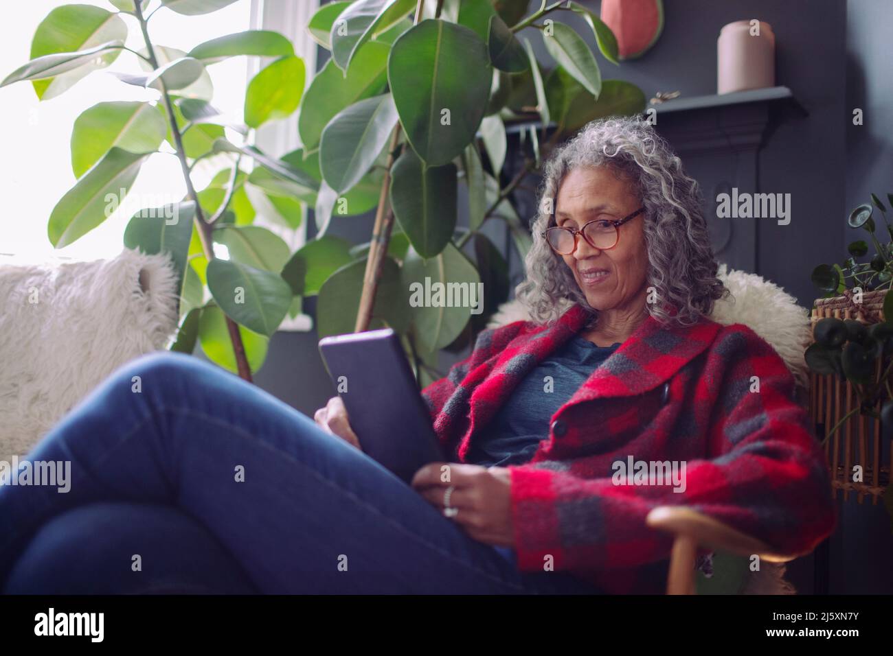 Senior woman using digital tablet at home Stock Photo
