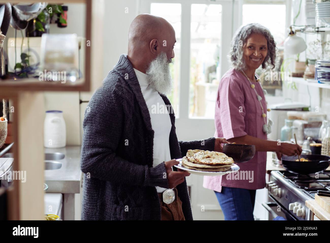 Happy senior couple cooking in kitchen Stock Photo - Alamy