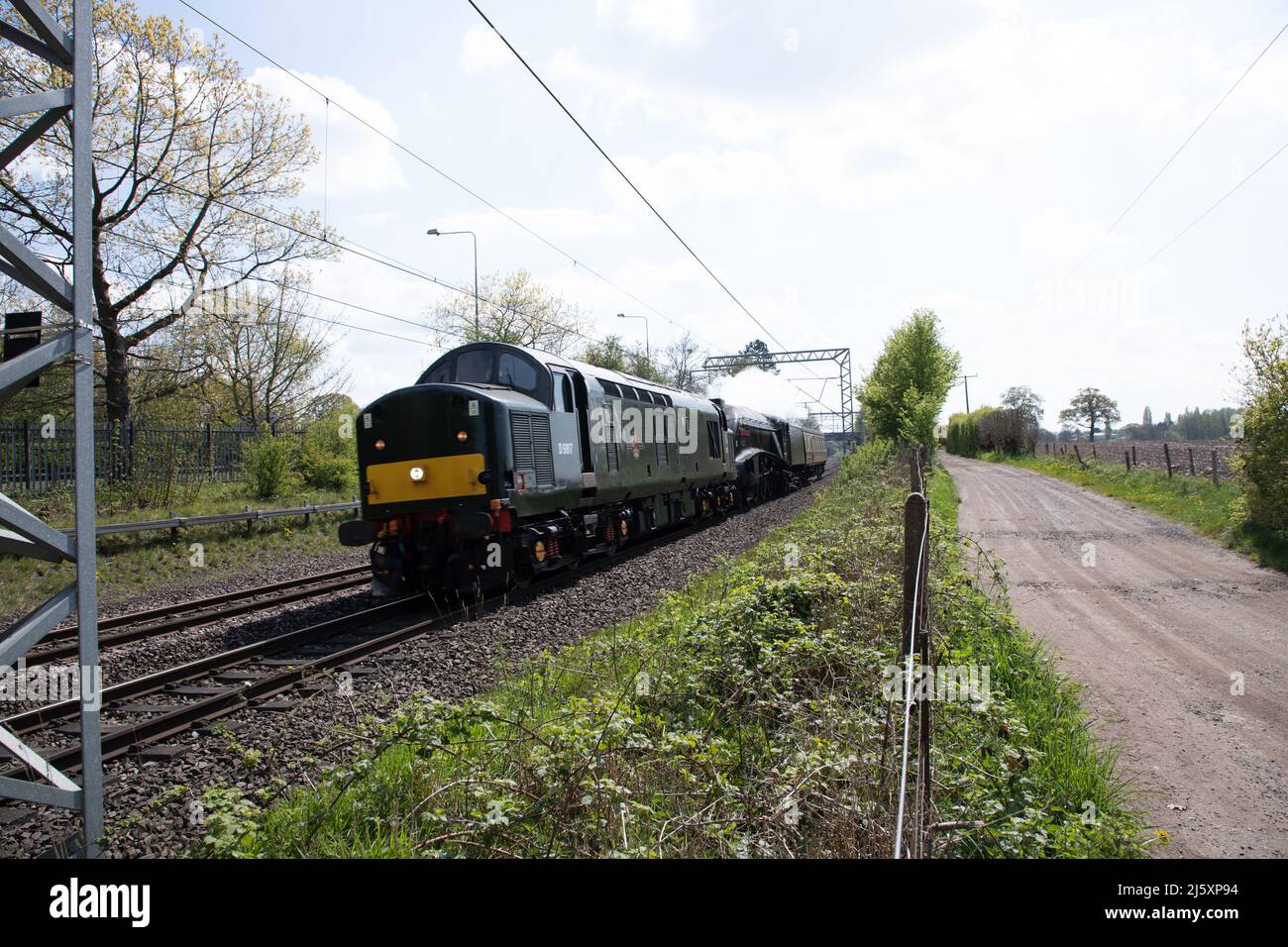 Staffordshire, UK 26th April 2022.  Steam train 60007 ”Sir Nigel Gresley” passes through Penkridge behind a diesel locomotive en route to Crewe after being the star attraction at the Severn Valley Railway Spring Gala over the weekend .  Credit Richard O'Donoghue/Alamy Live News Stock Photo