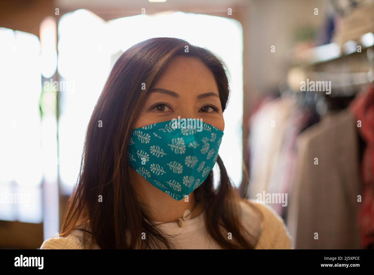 Portrait confident woman wearing face mask in shop Stock Photo