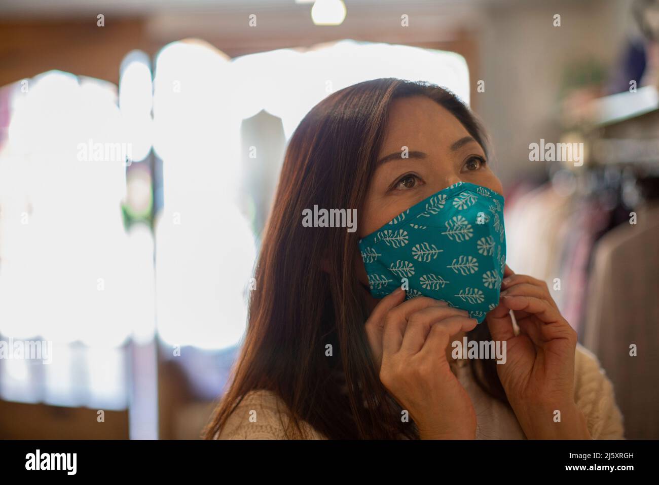 Woman wearing face mask in shop Stock Photo