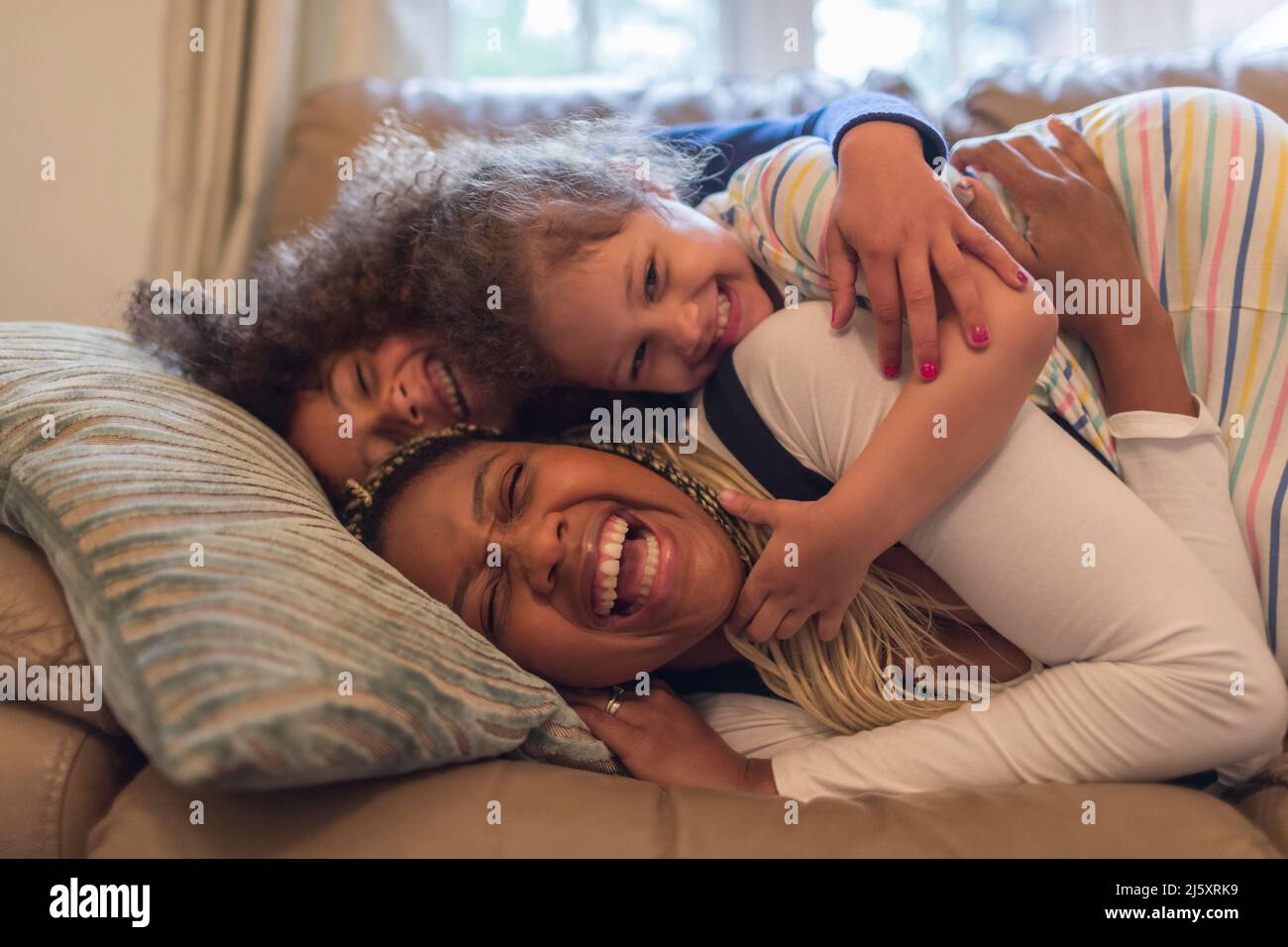 Portrait happy playful mother and children on sofa Stock Photo
