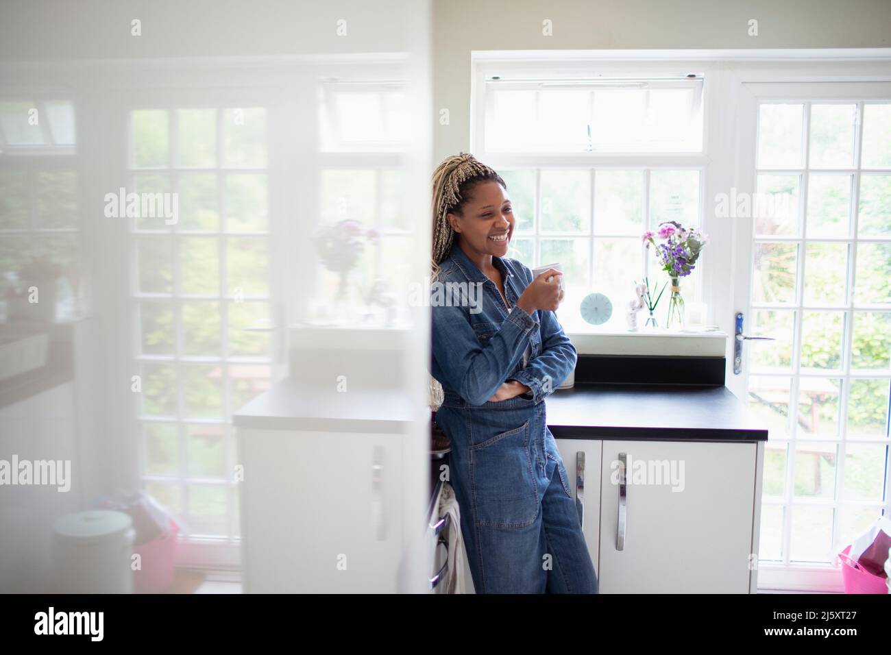 Happy woman drinking coffee in kitchen Stock Photo
