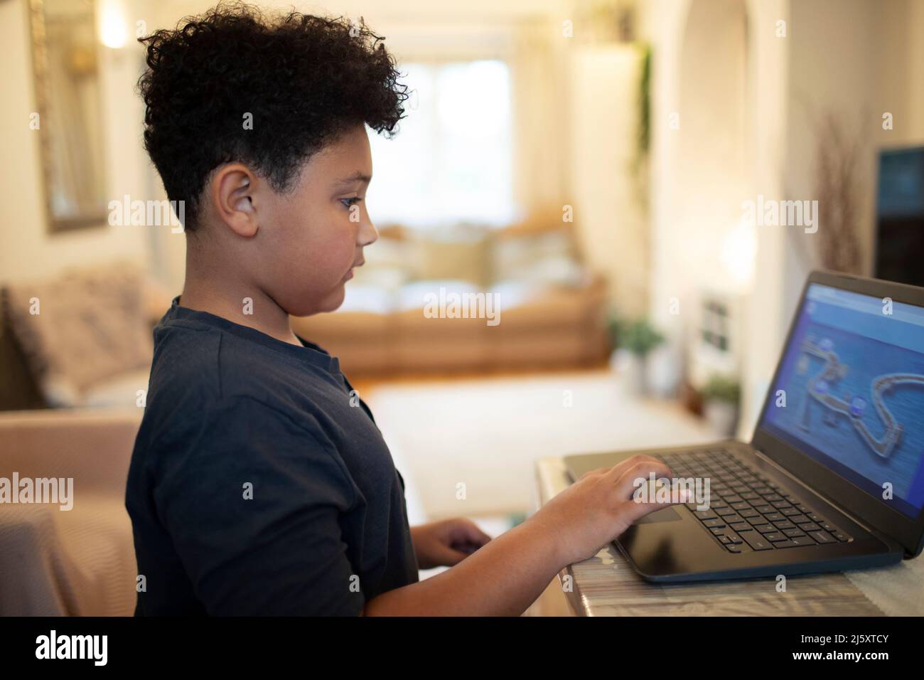 Boy playing video game at laptop Stock Photo