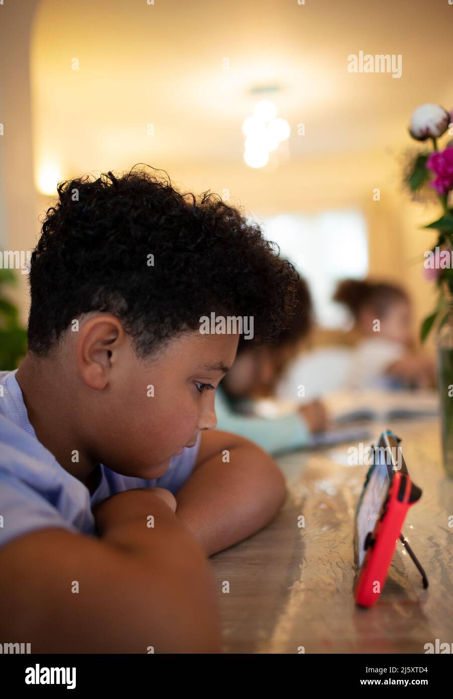 Boy playing video game at table Stock Photo - Alamy