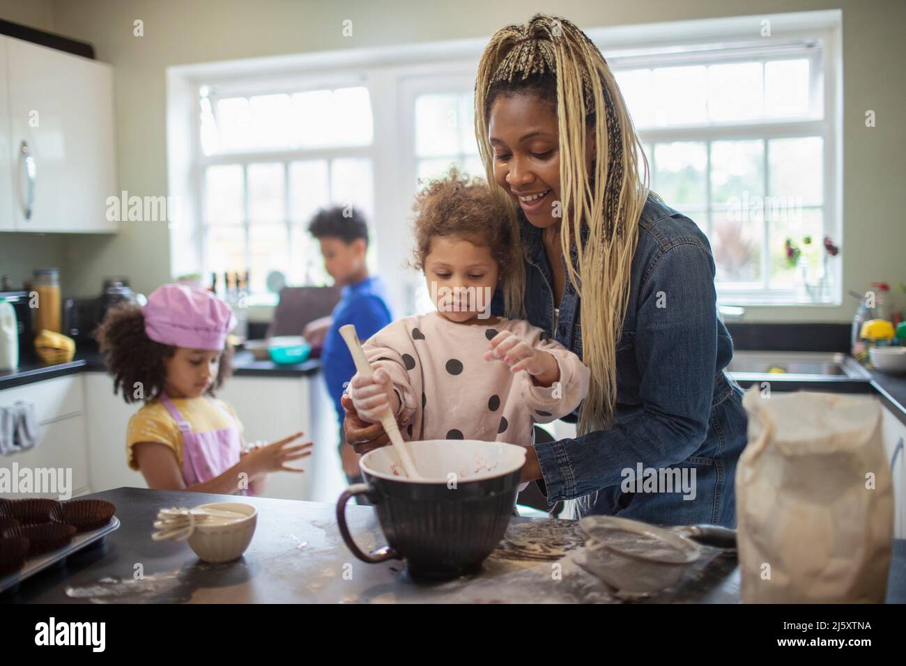 Mother and daughter baking in kitchen Stock Photo