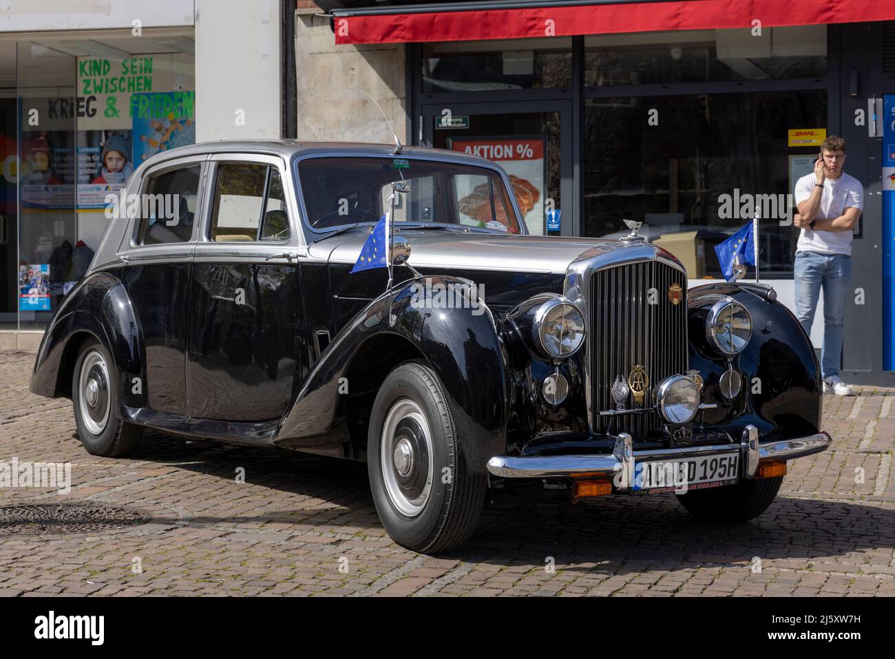 A vintage Rolls Royce car and one person in Aachen, Germany Stock Photo