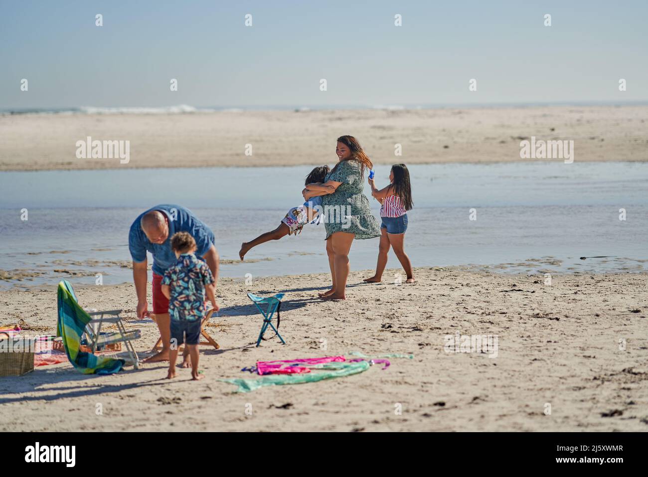 Family playing on sunny ocean beach Stock Photo