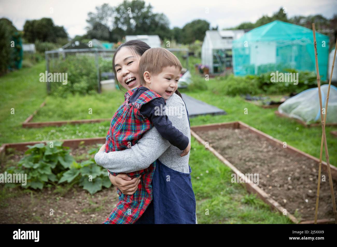 Happy mother and toddler son in vegetable garden Stock Photo