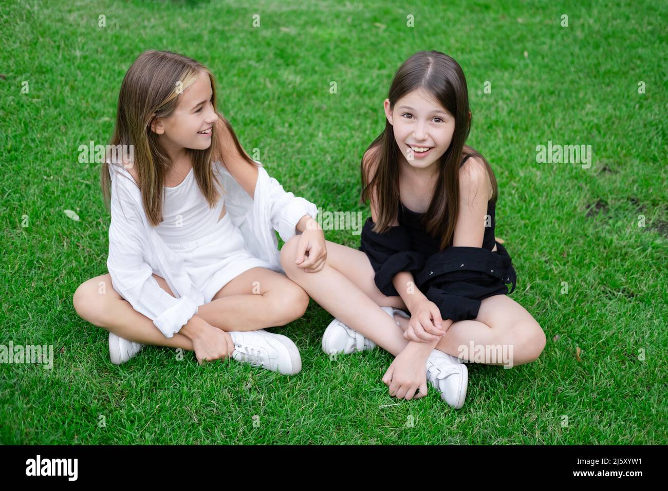 Fraternal Twins Sisters Blonde And Brunette Teen Girls In Fashionable Black And White Clothes