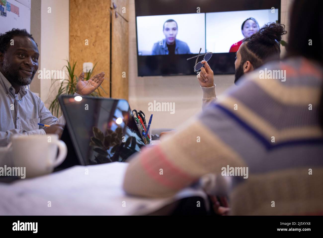 Business people video conferencing with colleagues in office Stock Photo