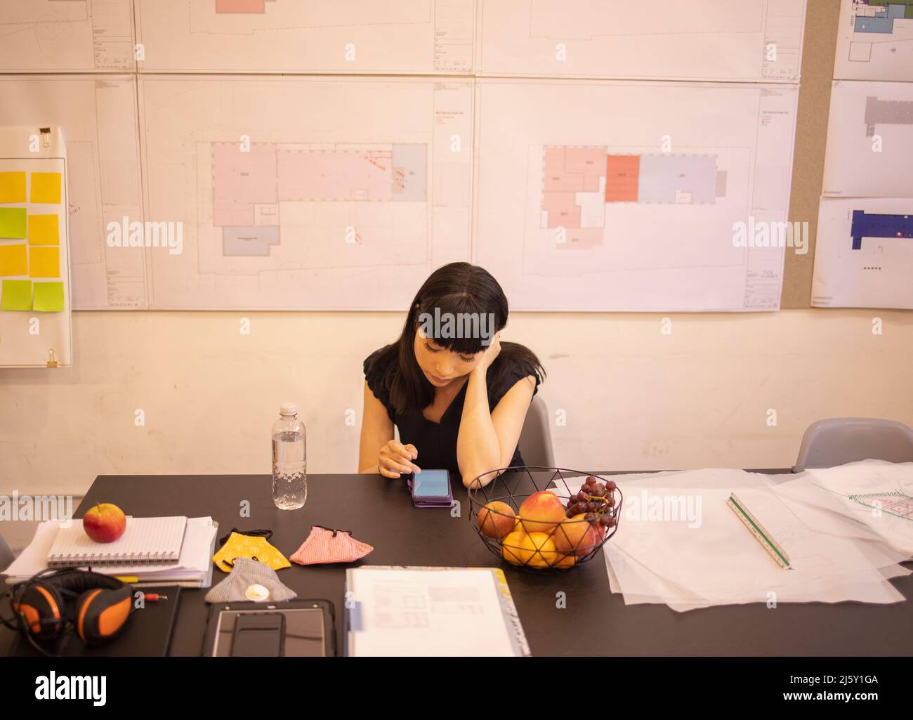 Female architect using smart phone in office Stock Photo