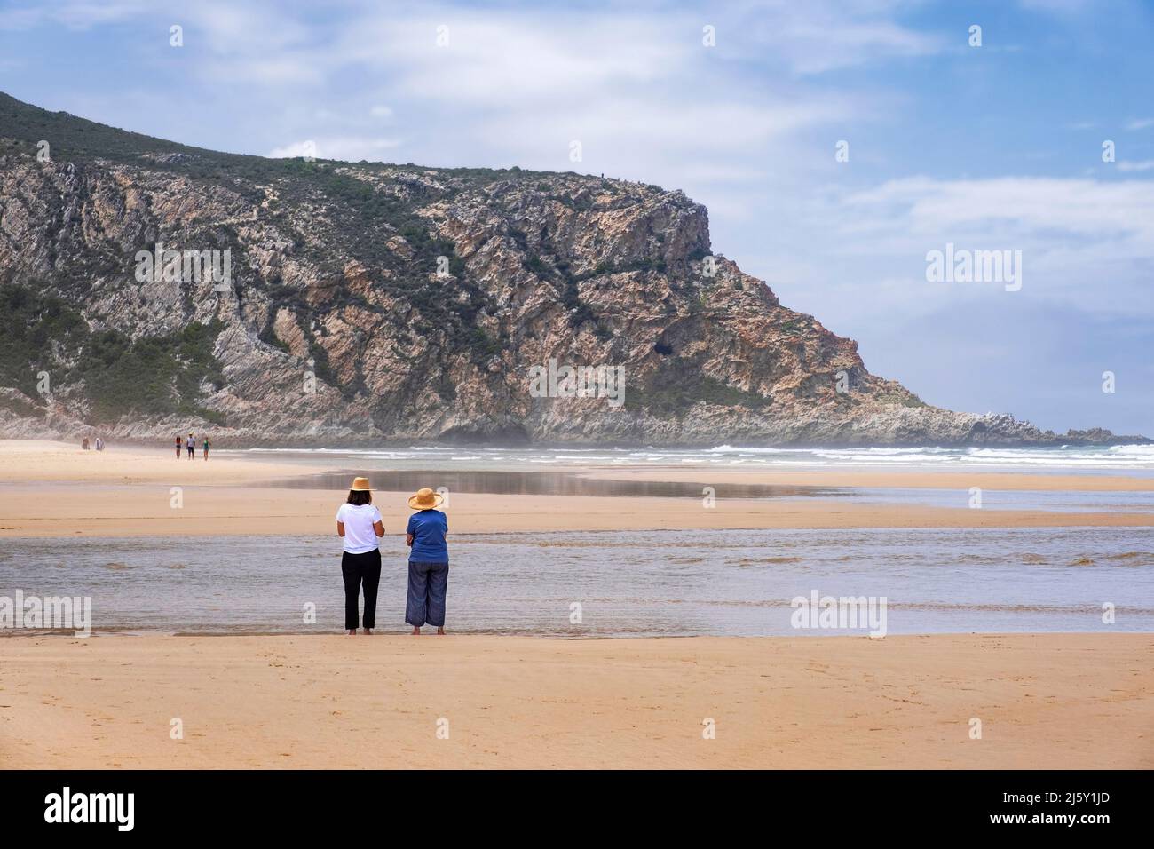 Tourists walking on Nature's Valley sandy beach in the Tsitsikamma Section of the Garden Route National Park, De Vasselot, Western Cape, South Africa Stock Photo