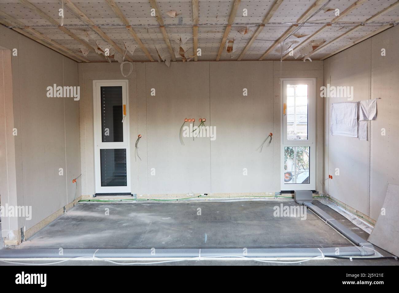 Empty room as shell in house construction with ventilation system and plasterboard wall Stock Photo