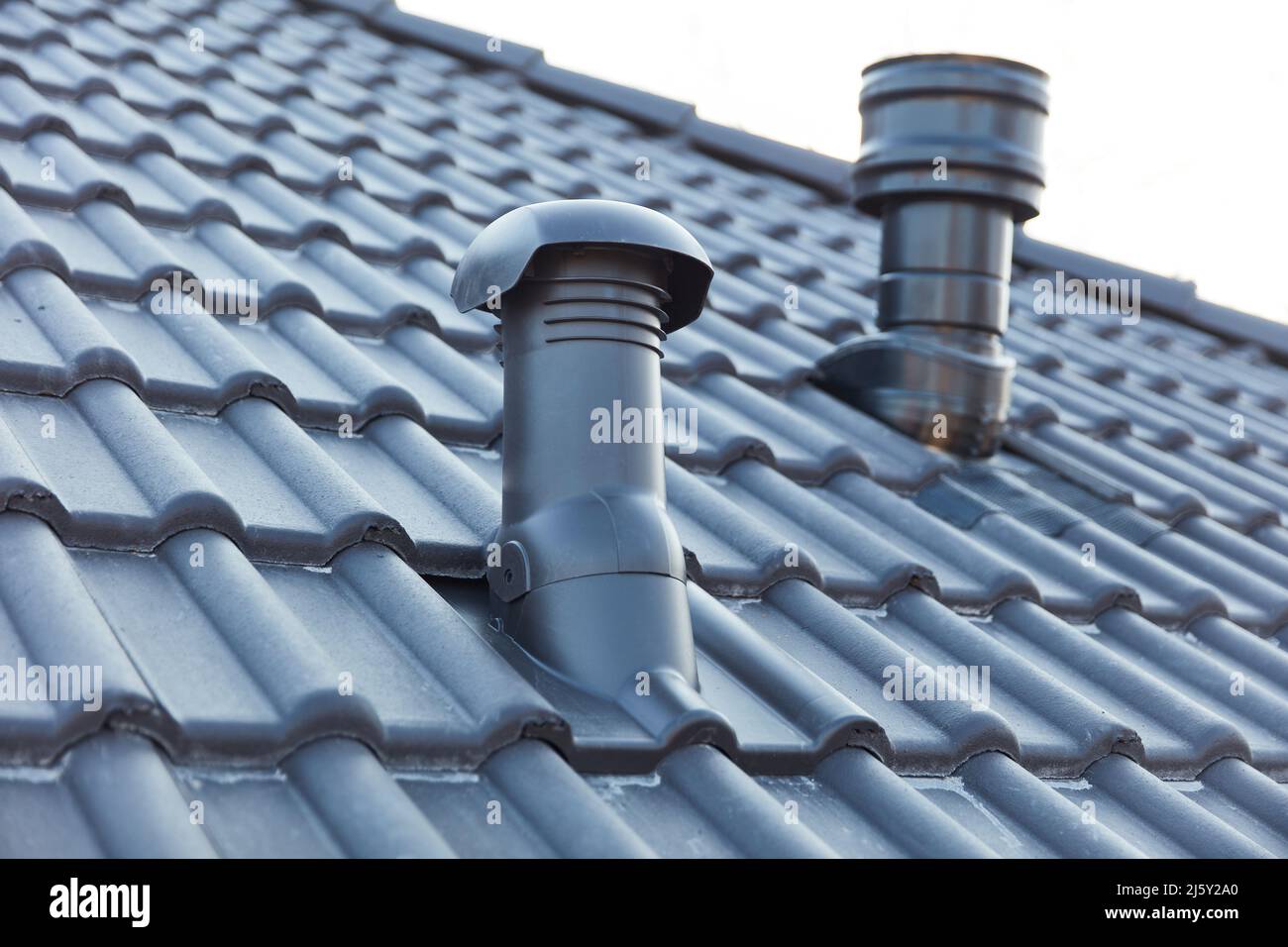 Small chimney and ventilation pipe on the roof of a new build house