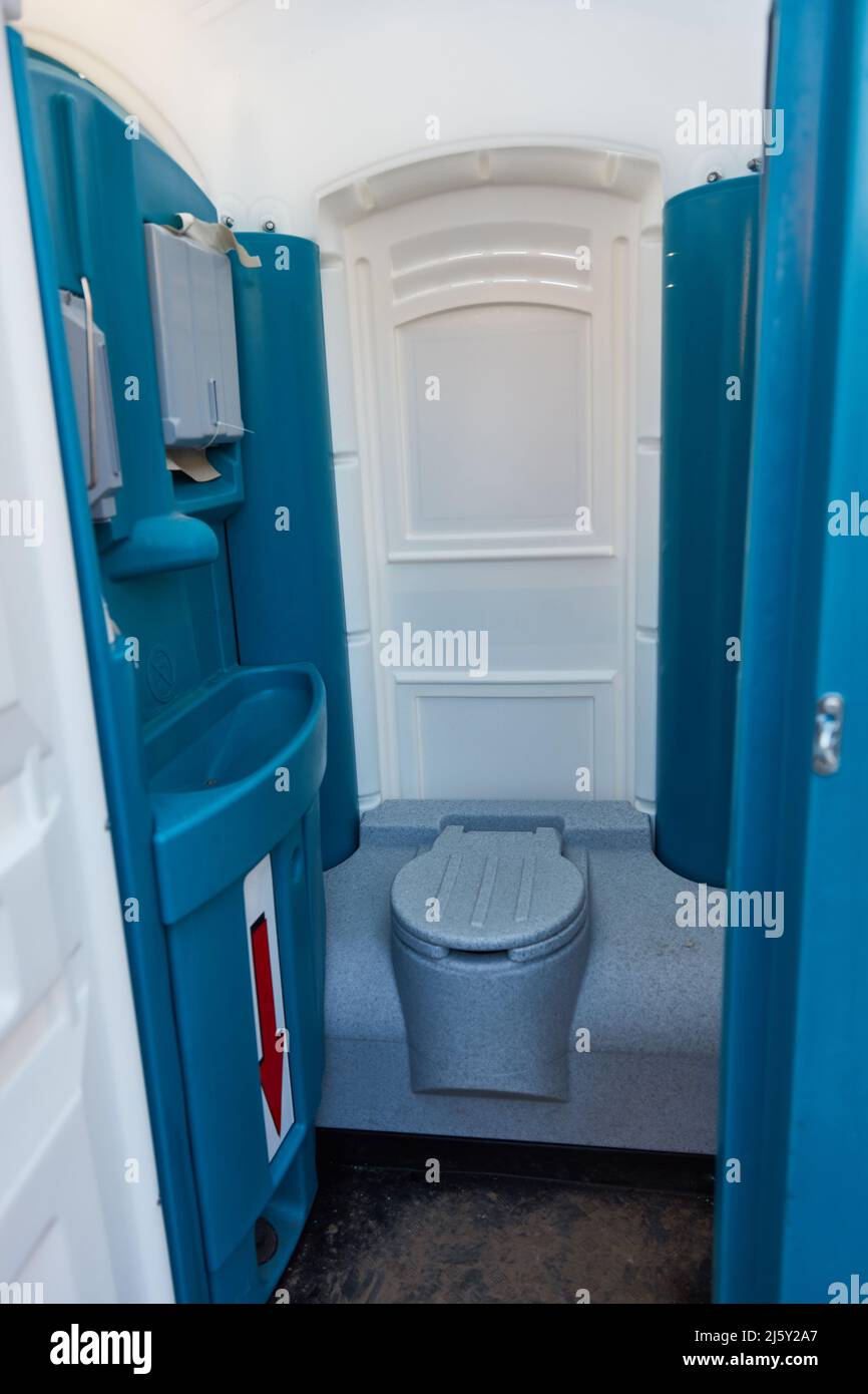 Mobile clean bright toilet cabin with toilet and sink Stock Photo
