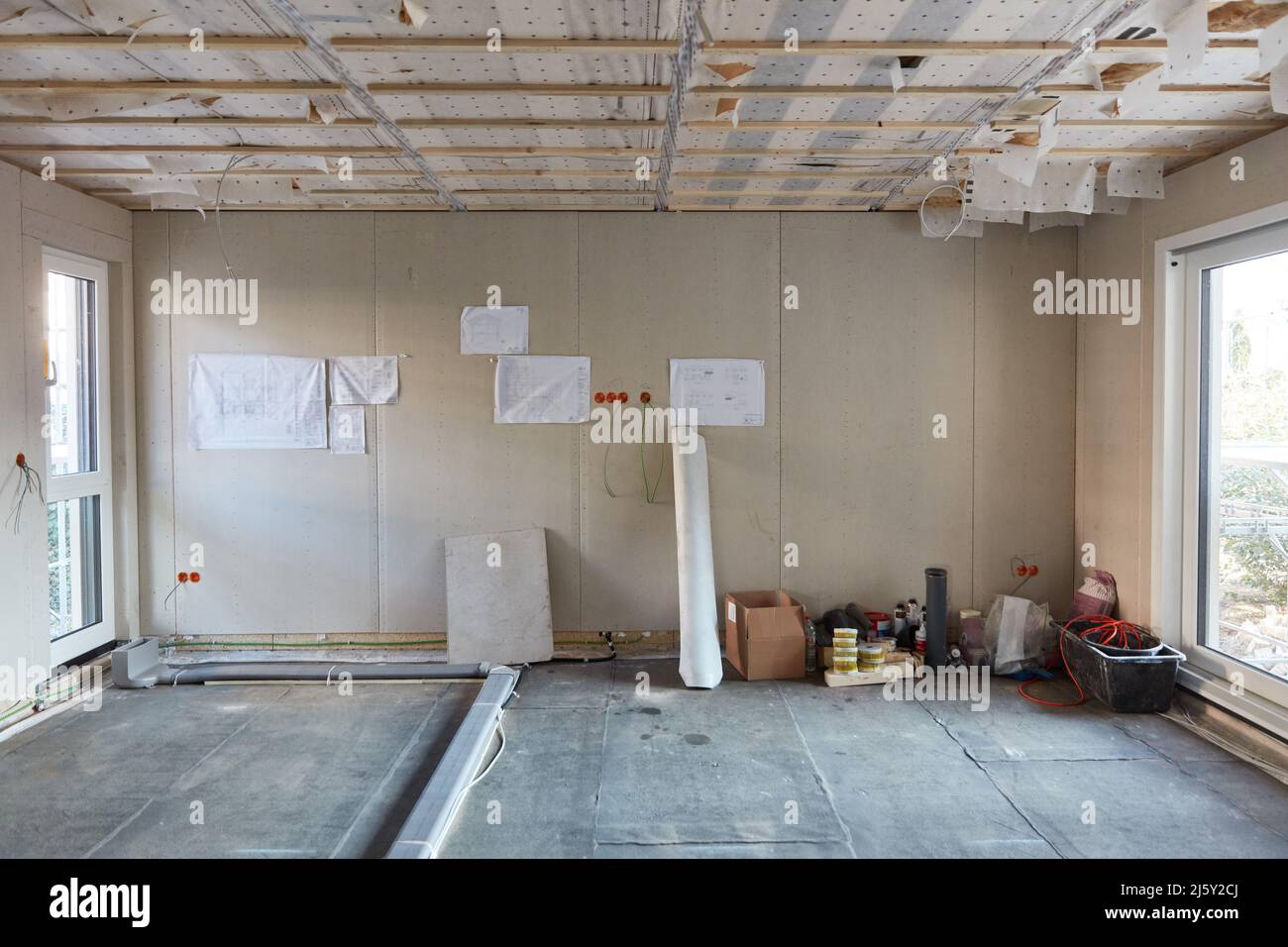 Large room in drywall house construction with blueprint on the wall Stock Photo