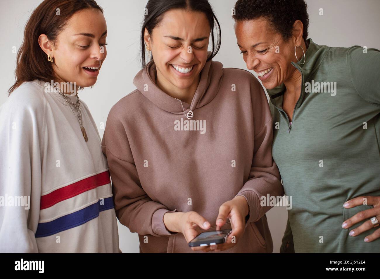 Happy mother and daughters using smart phone Stock Photo