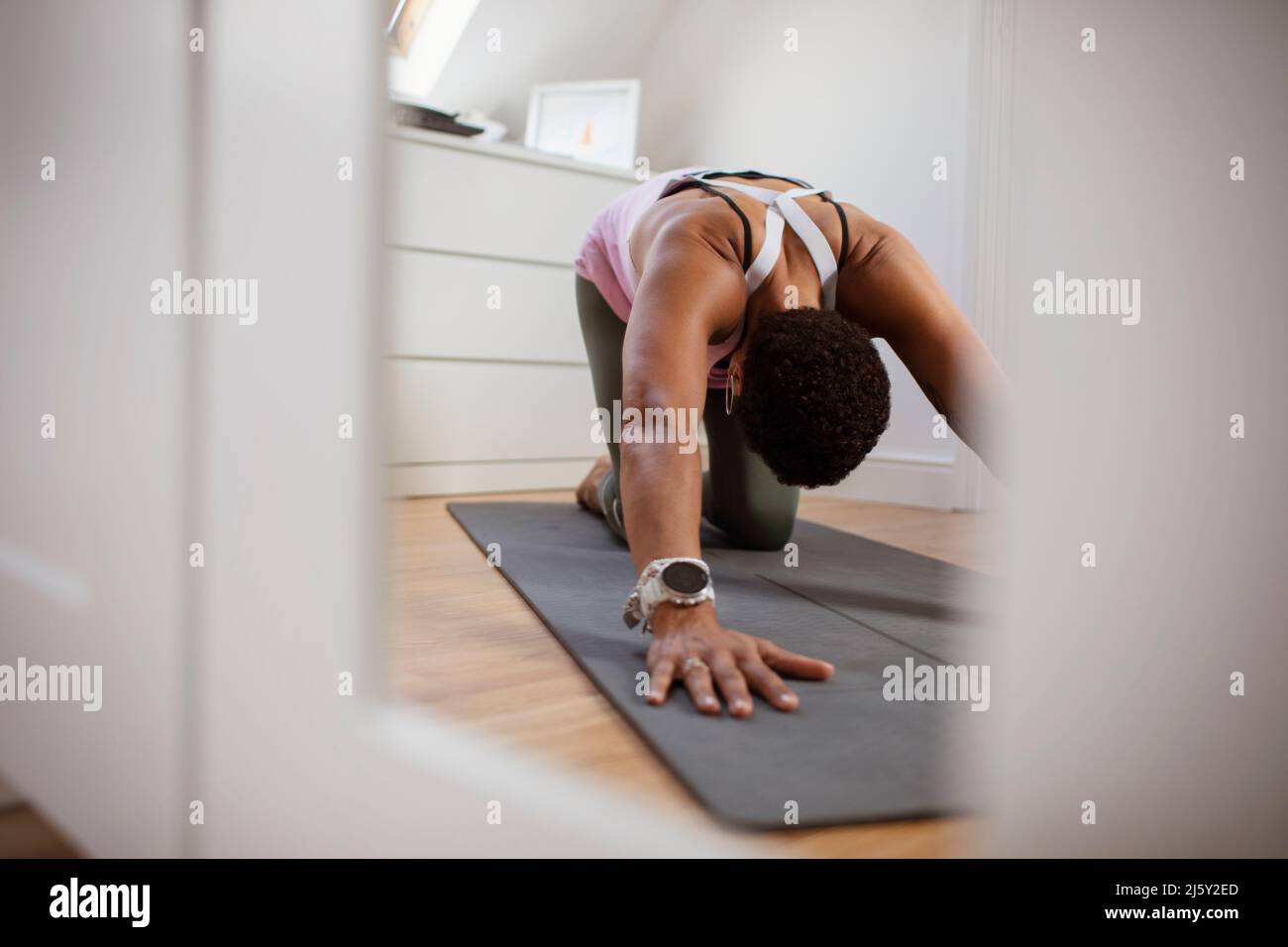 Woman practicing yoga child's pose on exercise mat Stock Photo
