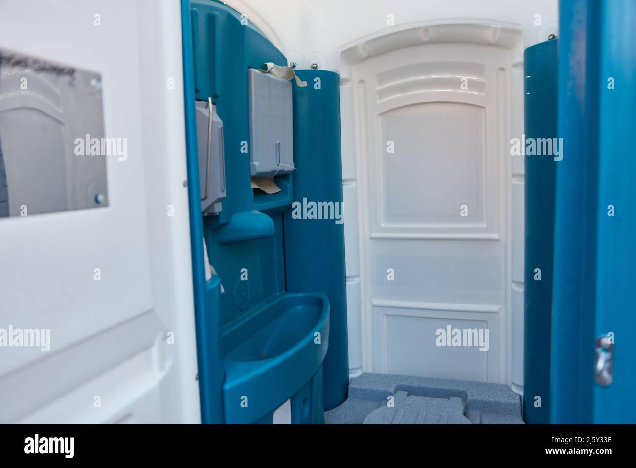 Mobile blue toilet cabin with hand wash basin and toilet Stock Photo