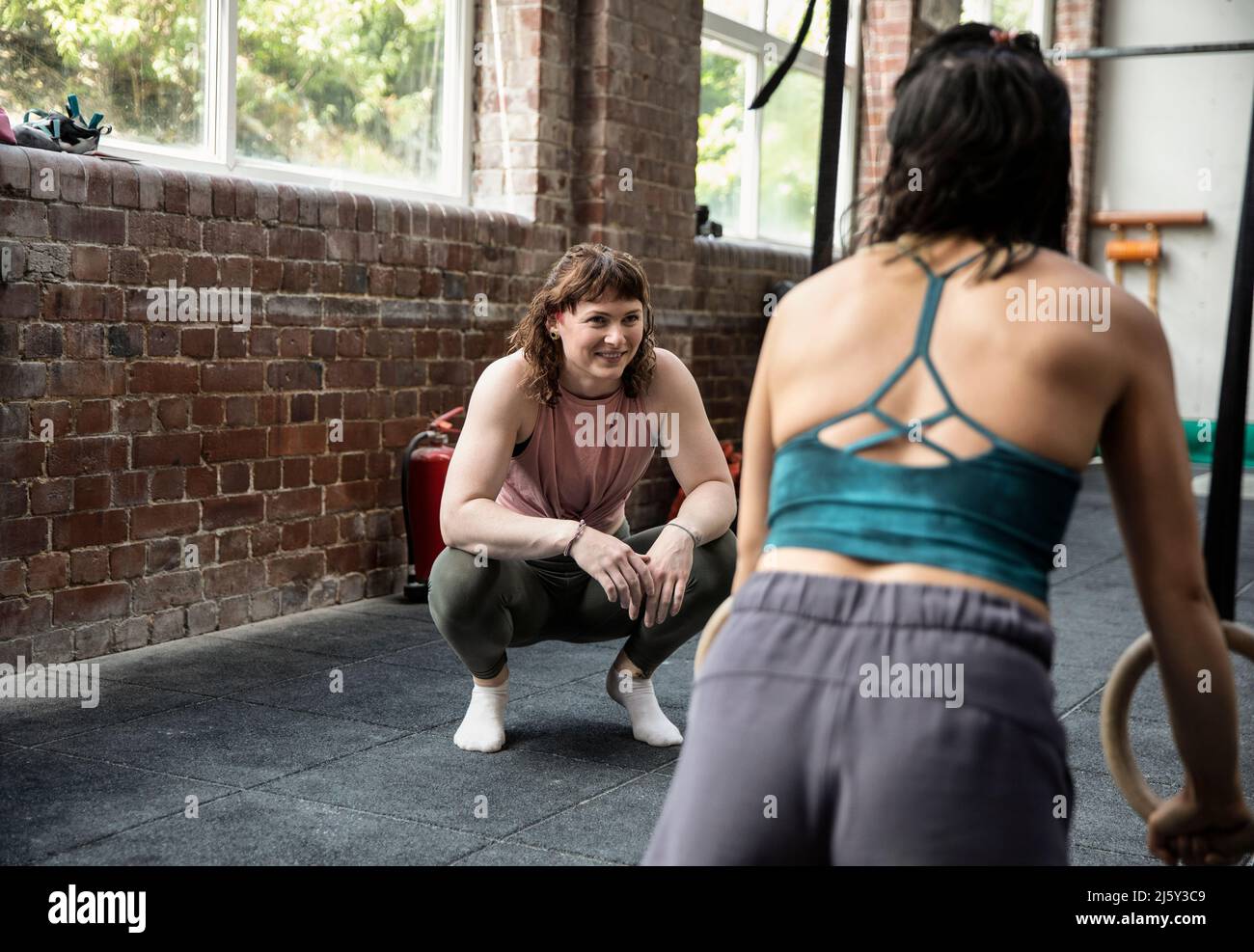 Smiling women friends working out in gym Stock Photo