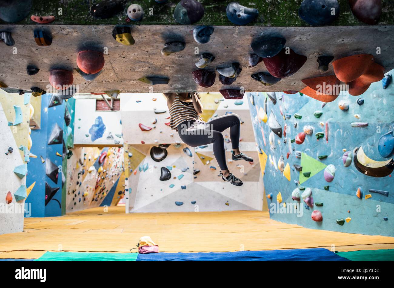 Female rock climber hanging from rock wall Stock Photo