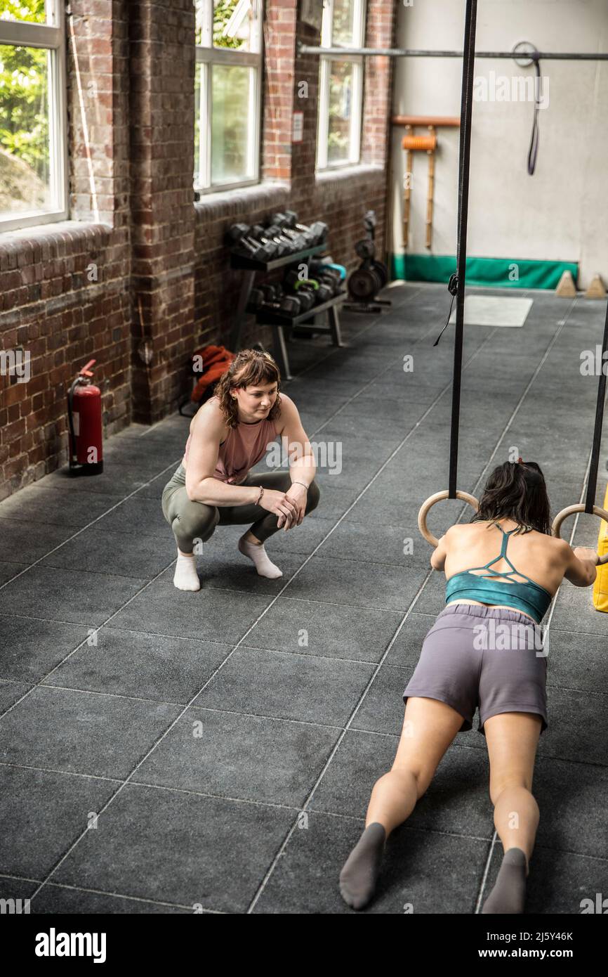 Personal trainer working with client in gym Stock Photo