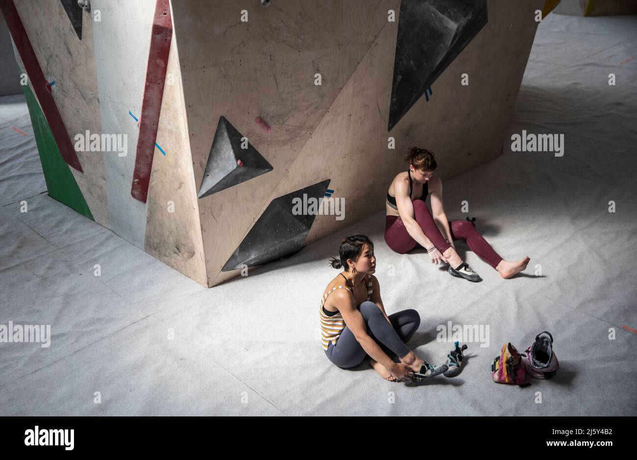 Women putting on shoes below rock climbing wall Stock Photo