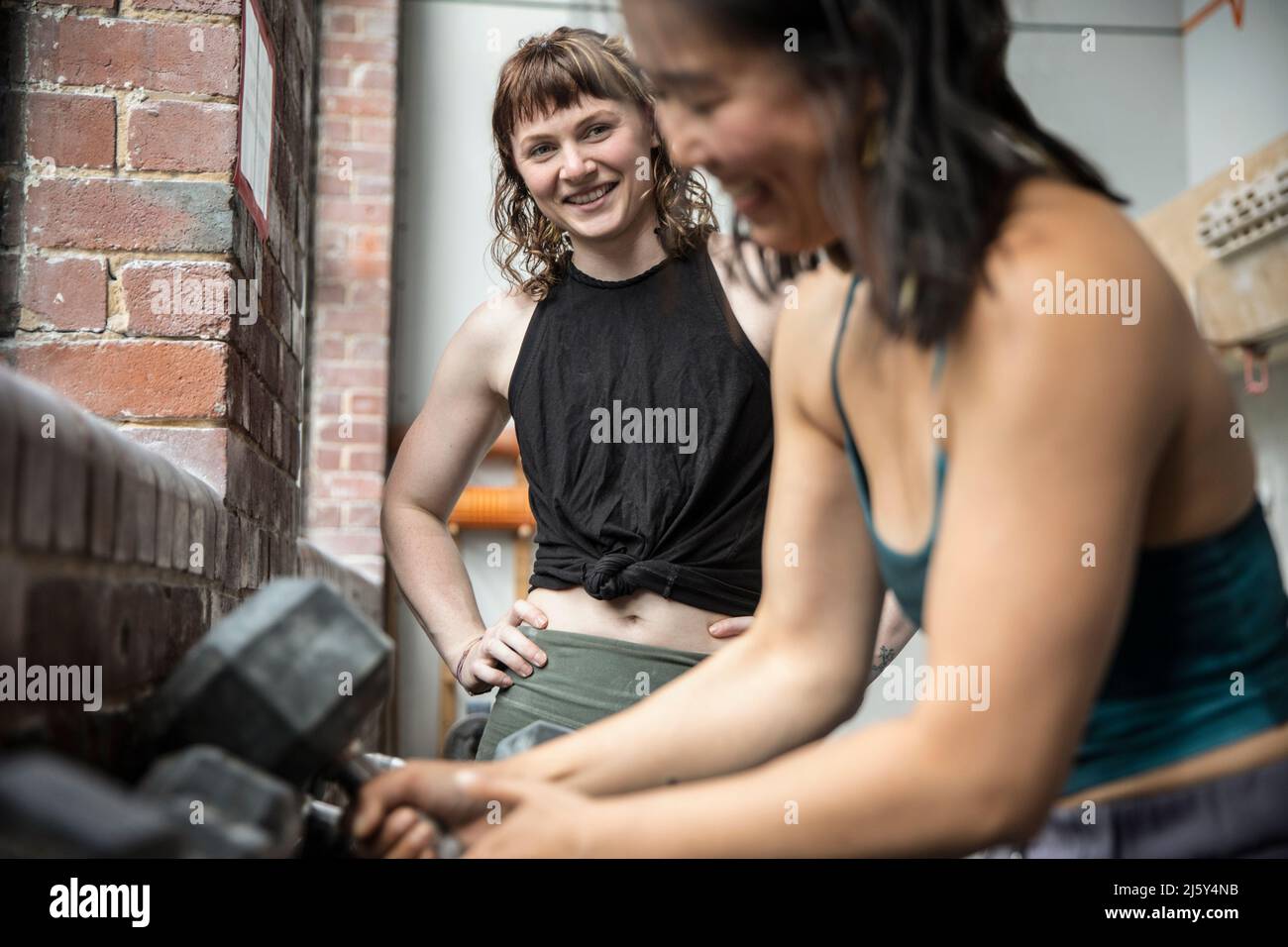 Smiling women friends working out at gym Stock Photo