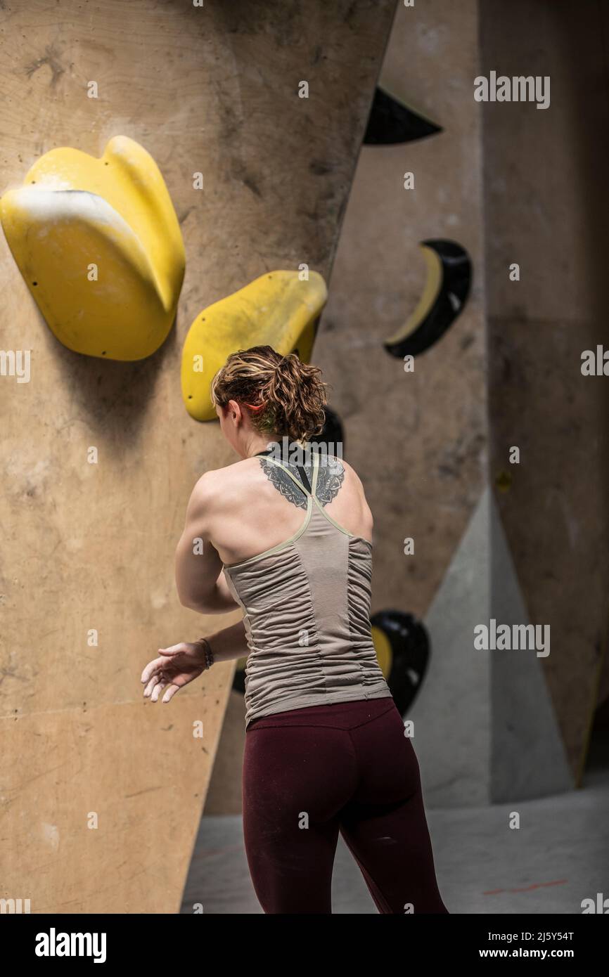 Young female rock climber standing below climbing wall Stock Photo