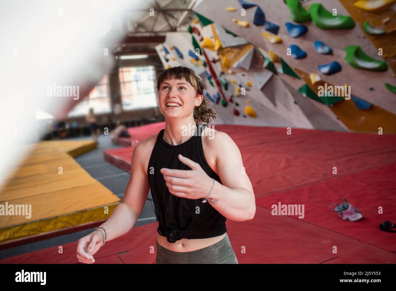 Happy young female rock climber in climbing gym Stock Photo