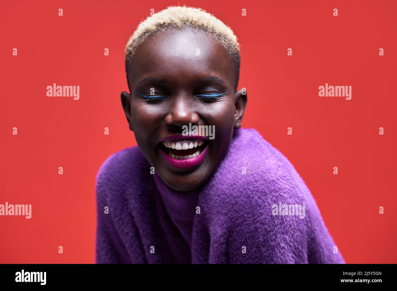 Portrait of a young African-American Woman looking at the camera on a red background Stock Photo