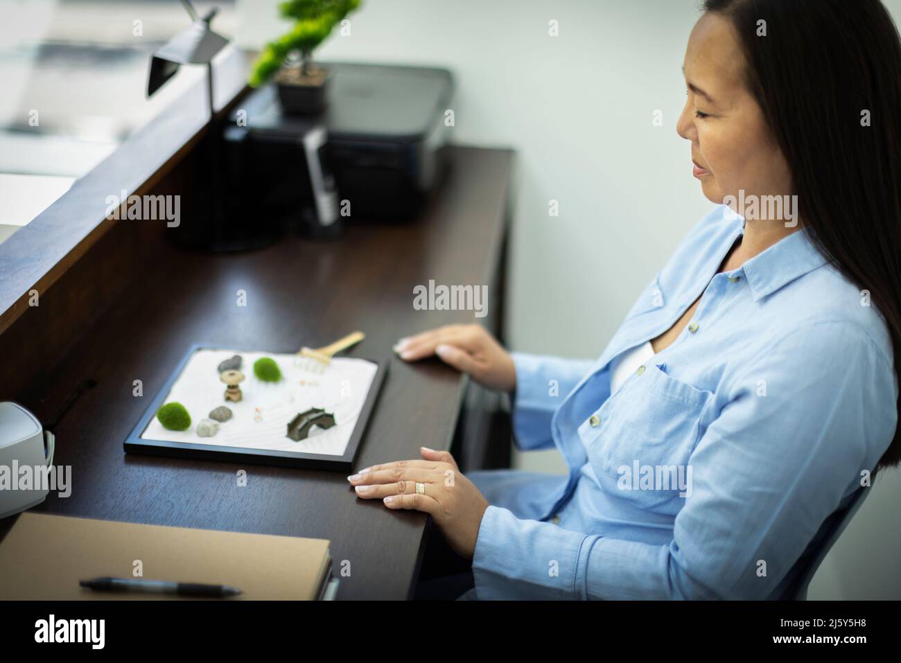 Businesswoman taking a break at mini zen garden Stock Photo