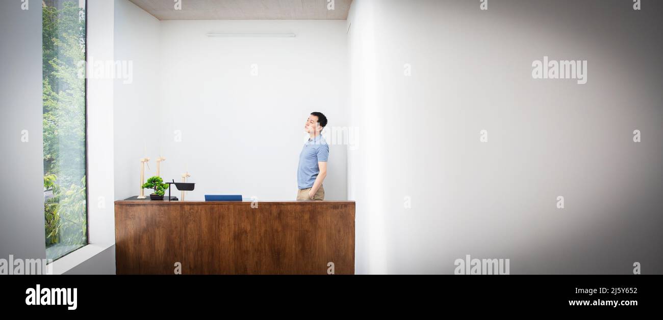 Thoughtful male engineer standing behind desk in office Stock Photo