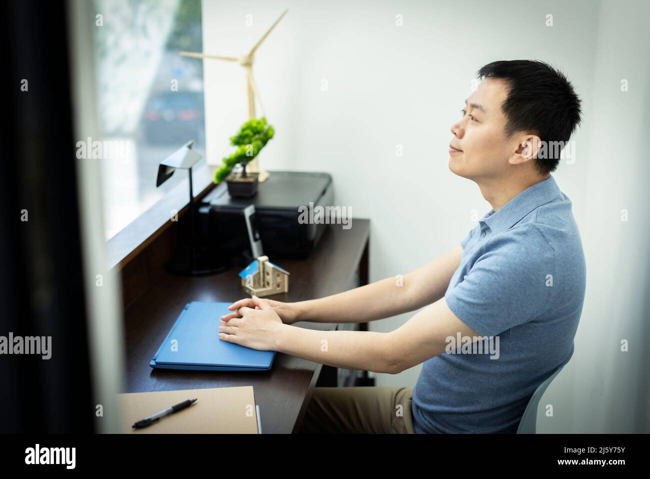 Happy male engineer sitting at desk in office Stock Photo