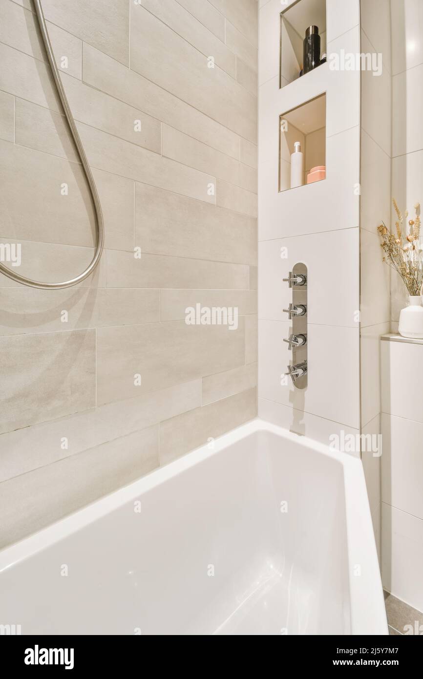 Detail of white ceramic bathtub located in contemporary bathroom with