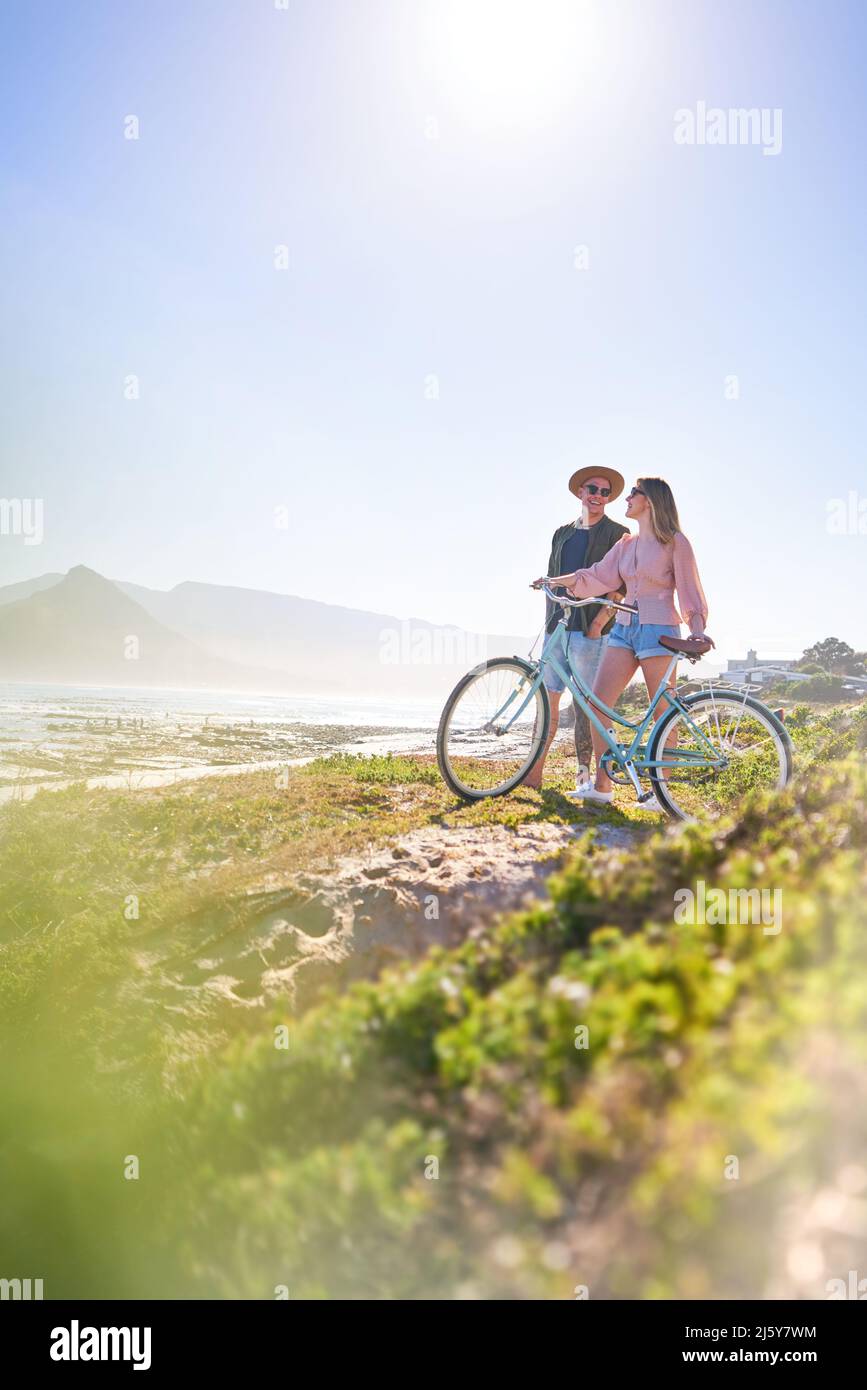 Happy couple with bicycle on sunny summer beach Stock Photo