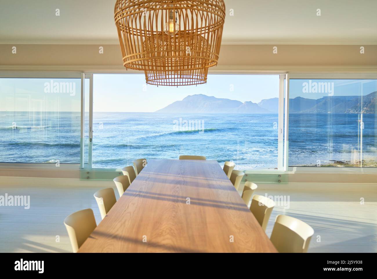 Rattan pendant lights over dining table with scenic ocean view Stock Photo