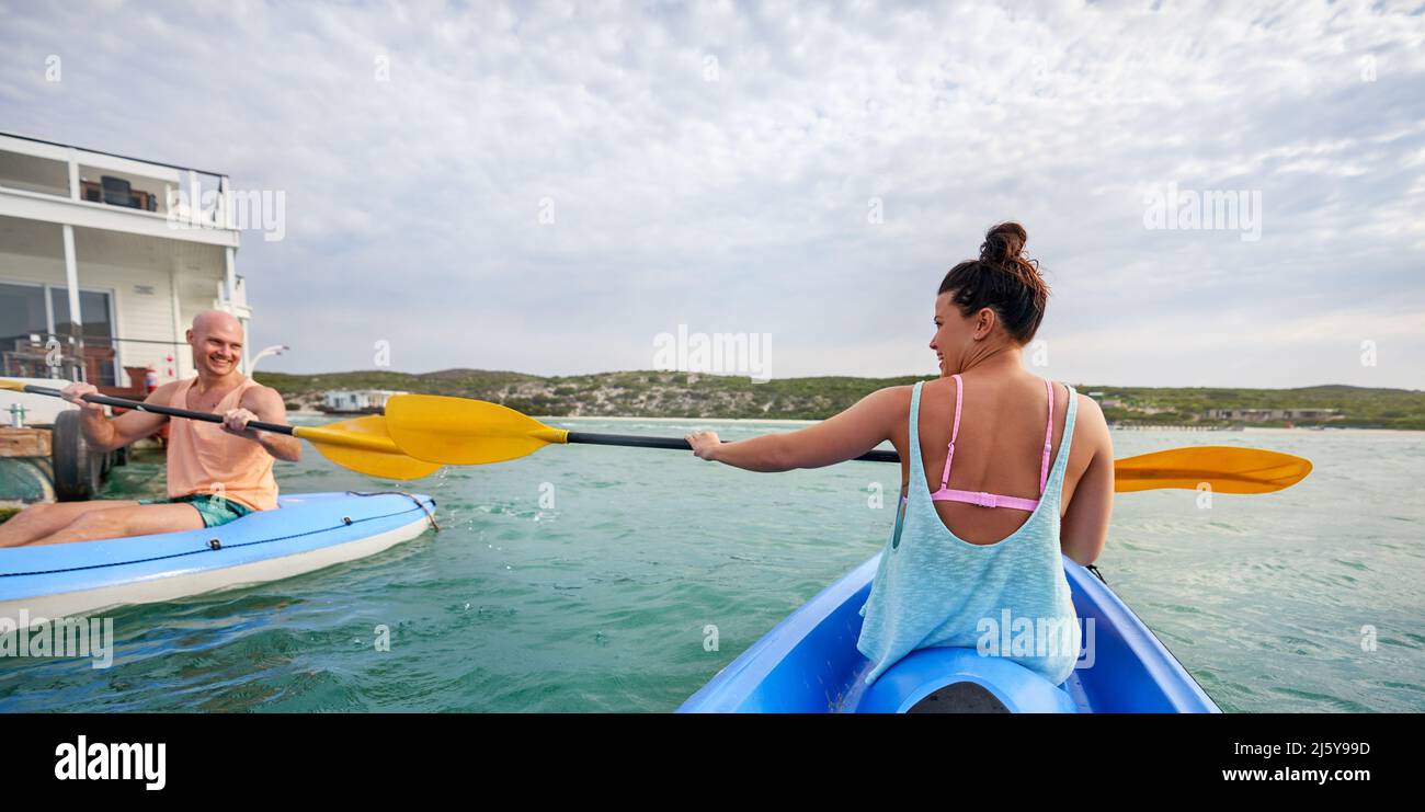 Couple with paddles kayaking on summer lake Stock Photo