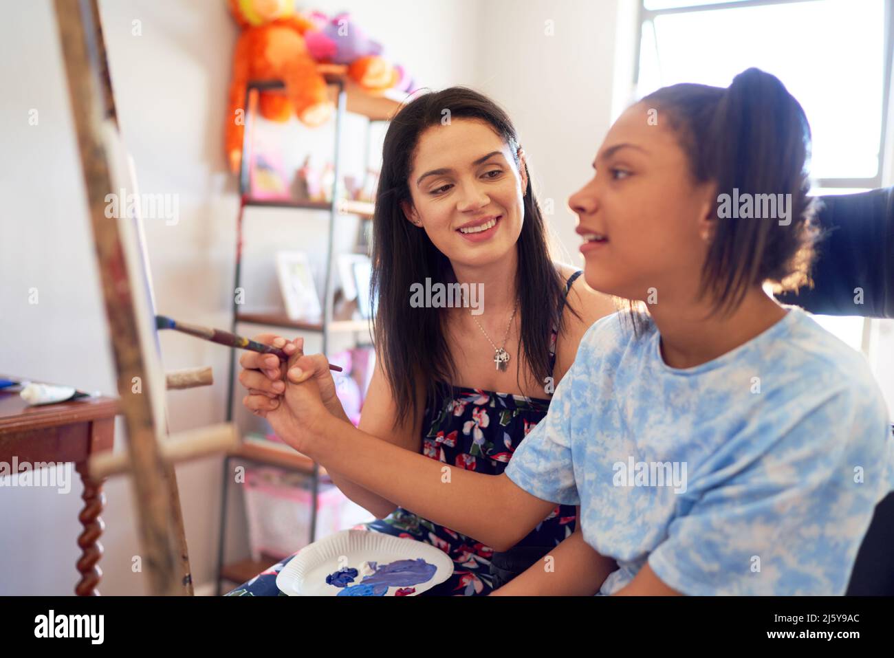 Mother and disabled daughter painting at home Stock Photo