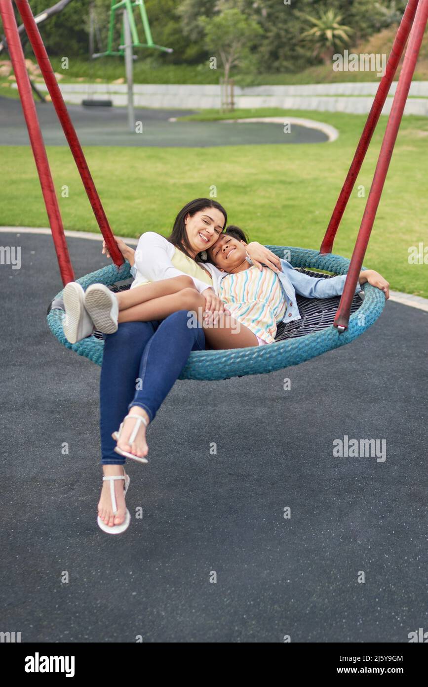 Portrait happy mother and daughter on playground trampoline swing Stock Photo
