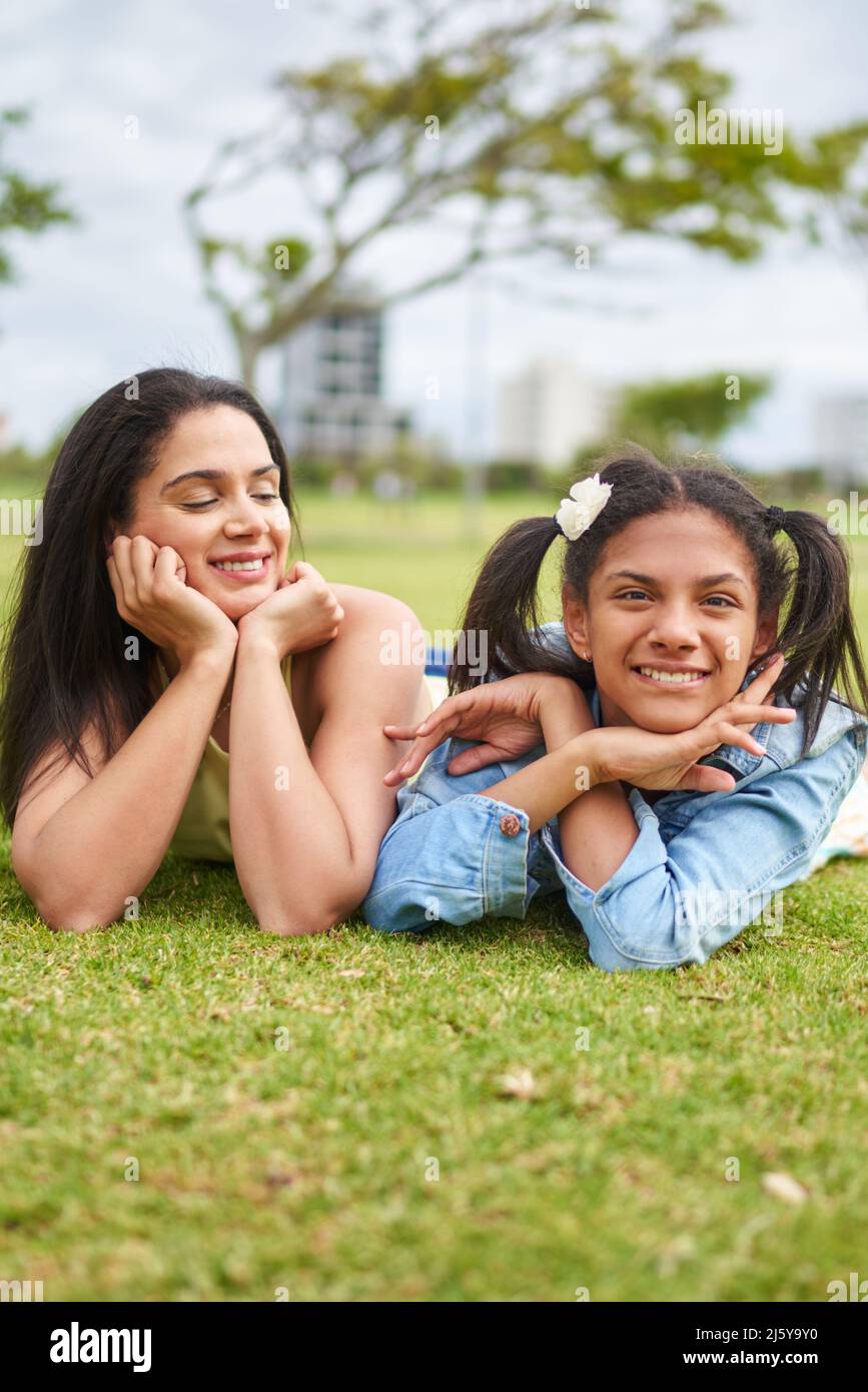 Portrait happy mother and daughter laying in park grass Stock Photo