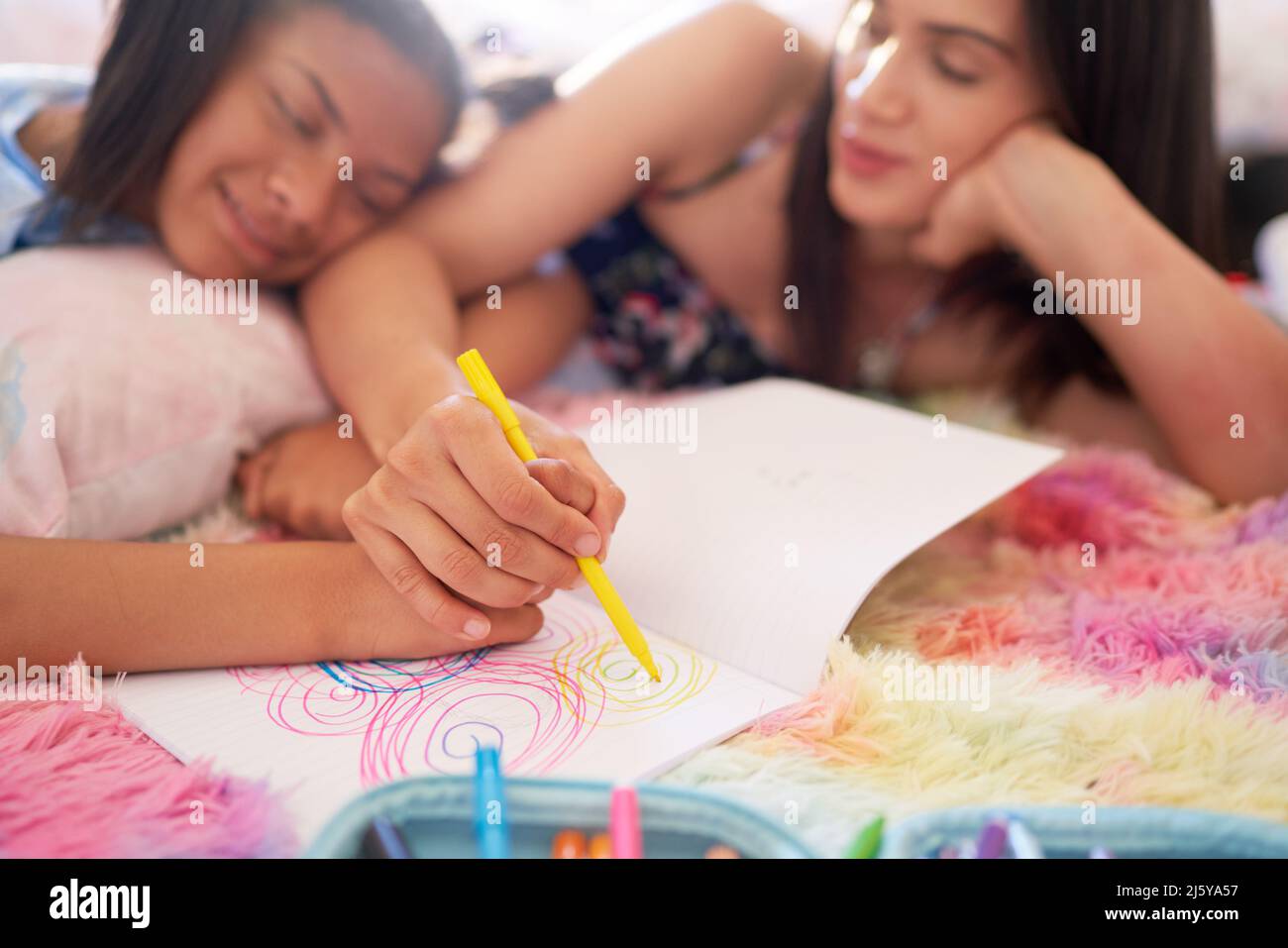 Mother and daughter drawing circles in notebook together Stock Photo