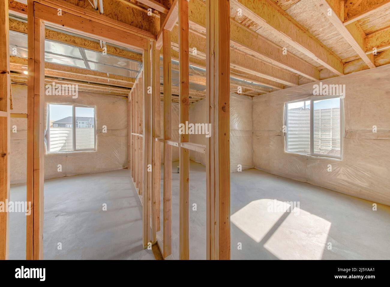 Unifinished basement interior with vapor barrier and windows with