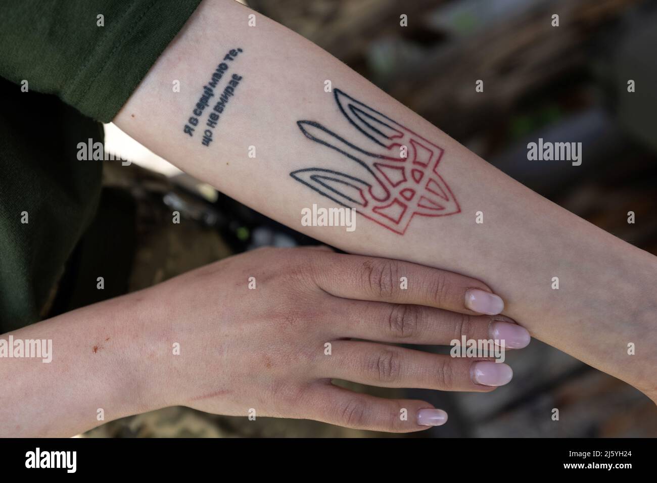 A 20-year-old paramedic volunteer Aleksandra shows a tattoo on her arm with  the Ukrainian coat of arms, a shield with a trident with words: 