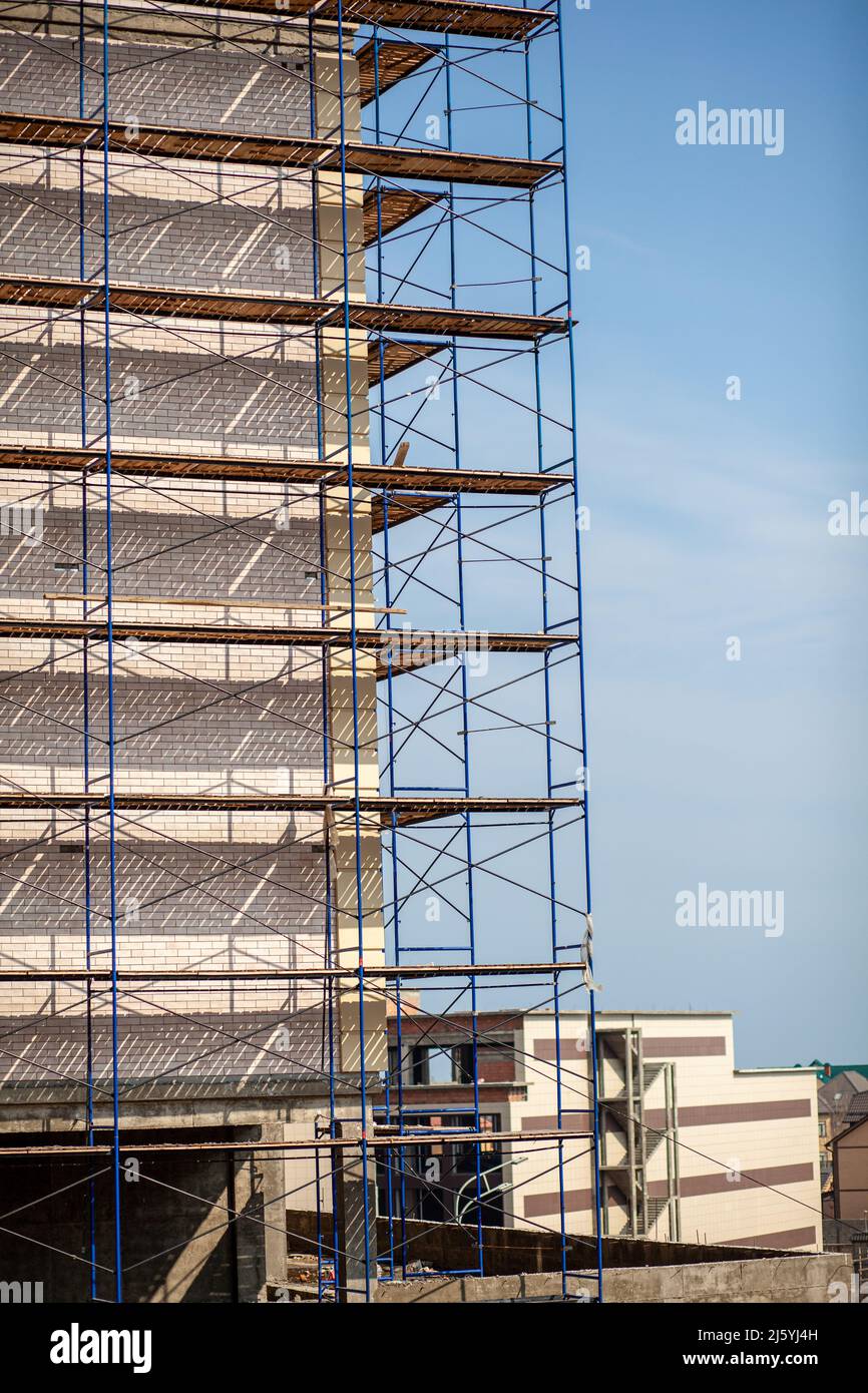 Scaffolding, metal mobile scaffold aginst blue sky background.  Stock Photo